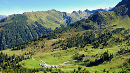 malerischer Blick auf  schönes Wandergebiet mit Wiesen, Bäumen und blauem Himmel im Vorarlberg