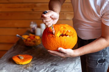 Man prepare for Halloween by carving pumpkin. close-up