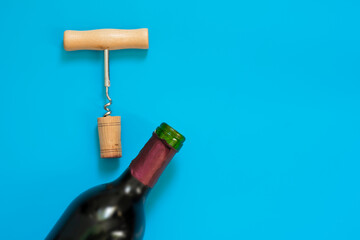 Wine cork and corkscrew on blue background