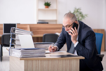 Naklejka premium Aged male employee sitting at workplace