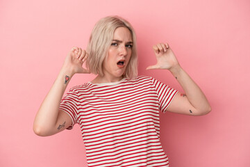Young caucasian woman isolated on pink background feels proud and self confident, example to follow.