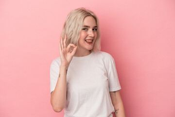 Young caucasian woman isolated on pink background cheerful and confident showing ok gesture.