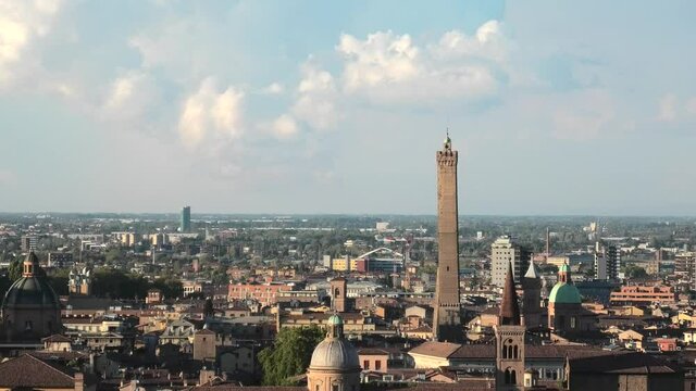 Cityscape with Two Towers of Bologna in Italy, symbol of city in the blue sky. Asinelli tower and Garisenda tower in historic downtown with ancient buildings of the city. Zoom out.