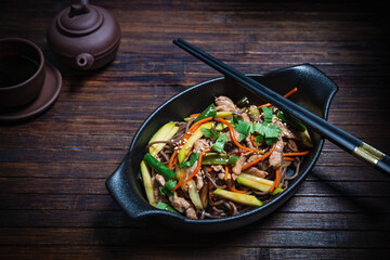 Asian style- restaurant background. Udon noodles with beef Wok