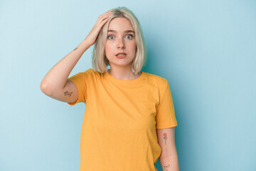 Young caucasian woman isolated on blue background being shocked, she has remembered important...