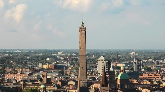 Close up of the tower on the cityscape of Bologna in Italy. The medieval Two Towers are the symbol of city in the blue sky. Asinelli and Garisenda tower in historic downtown with the town buildings.