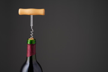 Wine bottle and wine opener on black background 