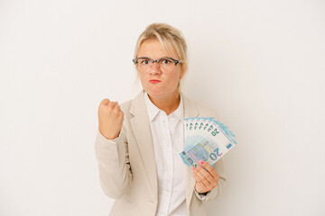 Young business Russian woman holding banknotes isolated on white background showing fist to camera, aggressive facial expression.