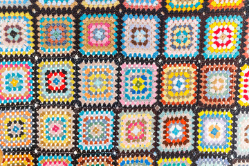 A bright Blanket with an ornament in the form of colorful squares woven from wool. The concept of fabric and national patterns