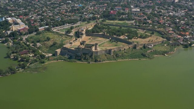 Belgorod-Dnestrovskaya fortress from a bird's eye view. The largest fortress in Ukraine is located on the Dniester River. Green blooming water and white-stone walls of the fortress.