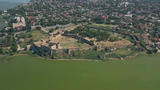 Belgorod-Dnestrovskaya fortress from a bird's eye view. The largest fortress in Ukraine is located on the Dniester River. Green blooming water and white-stone walls of the fortress.