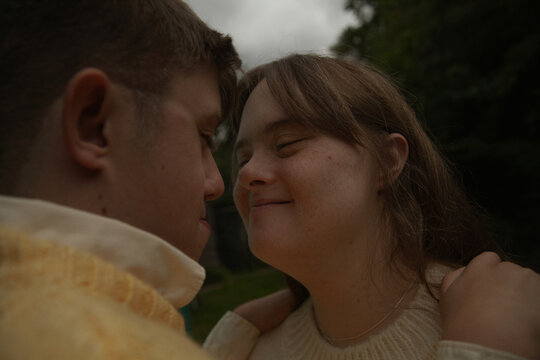 Face to face portrait of young couple with Down Syndrome and Foetal Alcohol Syndrome smiling