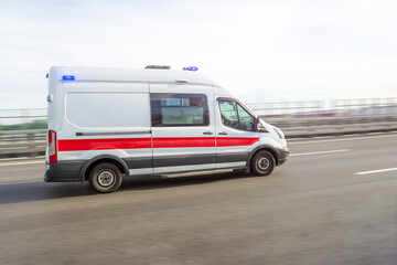 Ambulance car rushing down the highway on an emergency call, side view.