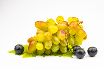 A bunch of pink grapes with green leaves isolated on a white background.