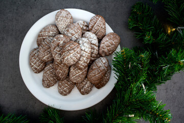 Christmas biscuits close up photo. Fir tree branches, anise stars, cinnamon sticks pine cone shaped cookies. 