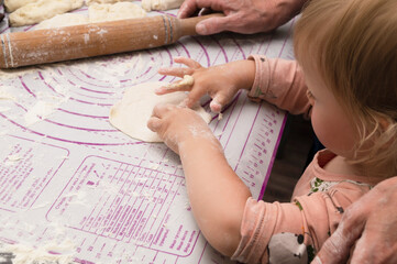 Obraz premium Cropped image of grandmother and granddaughter are cooking on kitchen. Making tasty baking together. Generation and happy family concept.