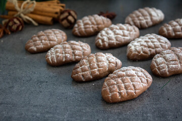 Christmas biscuits on dark gray textured background. Top view photo of cookies, cinnamon, anise and festive decorations. 