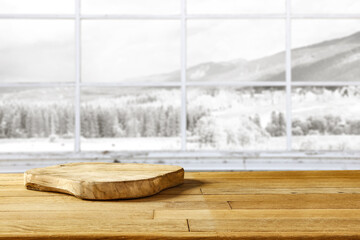 Wooden desk of free space and winter window background. 