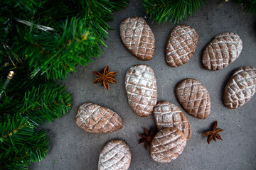Christmas biscuits close up photo. Fir tree branches, anise stars, cinnamon sticks pine cone shaped cookies. 