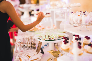 Delicious sweets on wedding candy buffet with desserts, cupcakes