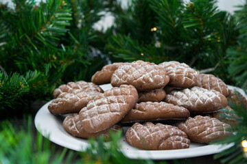 Christmas biscuits close up photo. Fir tree branches, anise stars, cinnamon sticks pine cone shaped cookies. 