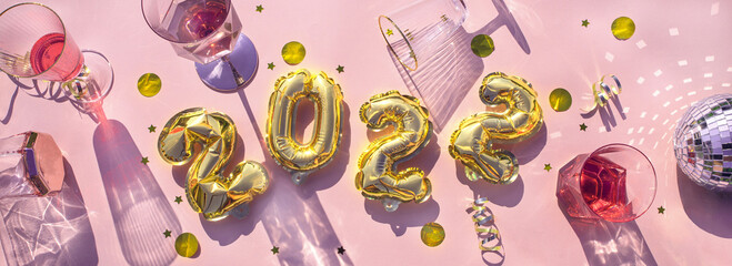 Gold balloons 2022, champagne glasses Concept fun New Years party