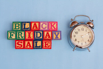 SPECTACULAR CONCEPT OF BLACK FRIDAY AND SALES WITH WOODEN CUBES AND WITH WOODEN SURFACE WITH OLD ALARM CLOCK.