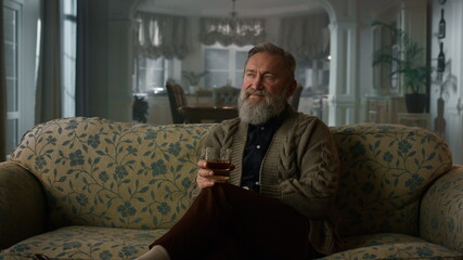 Fototapeta premium Rich senior man enjoy retirement life cognac. Confident old gentleman drinking