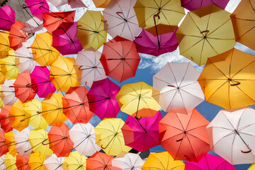 Fototapeta na wymiar The sky of colored umbrellas, Agueda street with umbrellas, Umbrella sky project in Agueda, Aveiro district