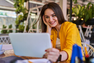 Happy smiling female worker speaking video call in office