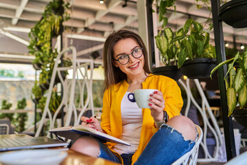 Happy smiling beautiful woman sitting and drinking coffee