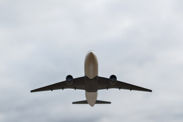 The concept of the trip is the take-off of a white plane. A model of a white airplane takes off into the sky, front view from below. Flight to 2022. I'm flying home. Departure on vacation.