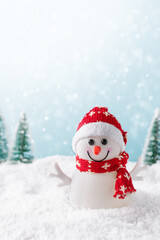 Christmas background with happy snowman standing in winter landscape. Christmas greeting card. Winter time.