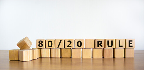 80 on 20 rule symbol. Wooden cubes with words '80 on 20 rule'. Beautiful wooden table, white background, copy space. Business and 80 on 20 rule concept.