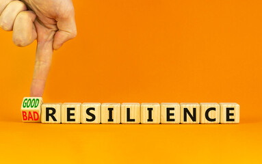 Good or bad resilience symbol. Businessman turns a wooden cube, changes words bad resilience to good resilience. Beautiful orange background, copy space. Business, good or bad resilience concept.