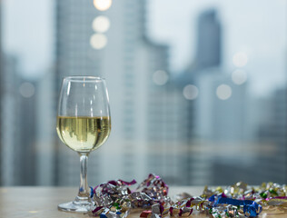 Glass of white wine on table and blurred city background