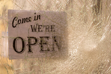 割れたガラスとCome in, We are openのサイン