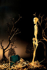 Creepy skeleton with red eyes standing at the graveyard on the dark night. Halloween concept.