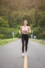 A sporty woman in sportswear exercises at the garden in front of her home