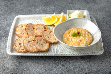 Pike caviar, butter with crispy croutons and lemon appetizer. Ready menu for the restaurant. Neutral gray blue textured background