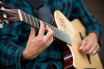 Closeup of hands of musician playing guitar in the street