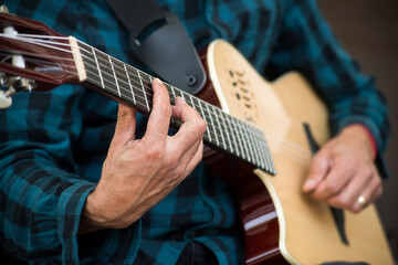 Fototapeta na wymiar Closeup of hands of musician playing guitar in the street
