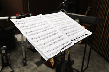Fototapeta na wymiar Note stand with music sheets at recording studio. Band practice