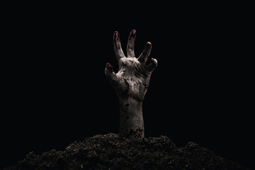 Creepy bloody and dirty hand rising from the ground. Black background. Horror and Halloween theme.