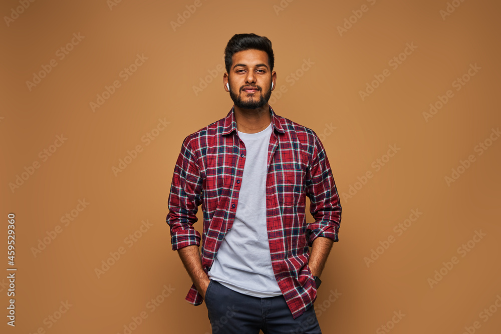 Wall mural stylish handsome indian man in tshirt on pastel background