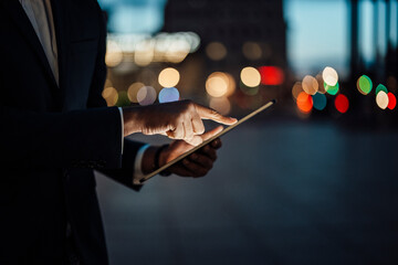 Mature businessman working on digital tablet at night