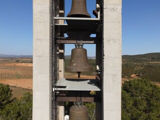 Beautiful monastery of Montserrat, with cultivated fields, bells and the blue sky in the background