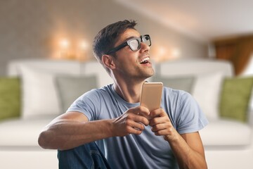 Cheerful Millennial Man Using Cellphone Browsing Internet And Texting