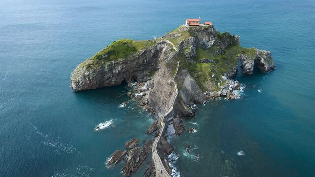 Aerial view of a stunning landscape in San Juan de Gaztelugatxe islet on a sunny day, coast of Biscay, Spain. High quality 4k footage