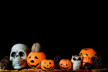 Halloween human skull, Halloween Pumpkins on an old wooden table in front of black background with free space for text.